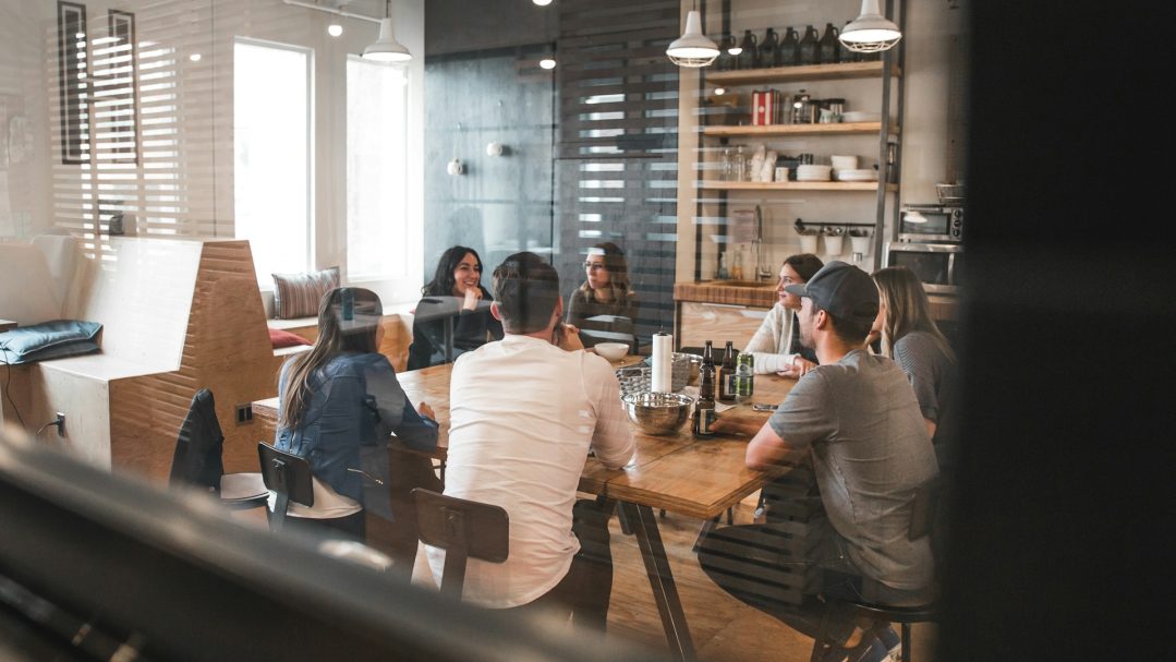 Un groupe de personnes assises autour d'une table dans un espace de travail convivial.